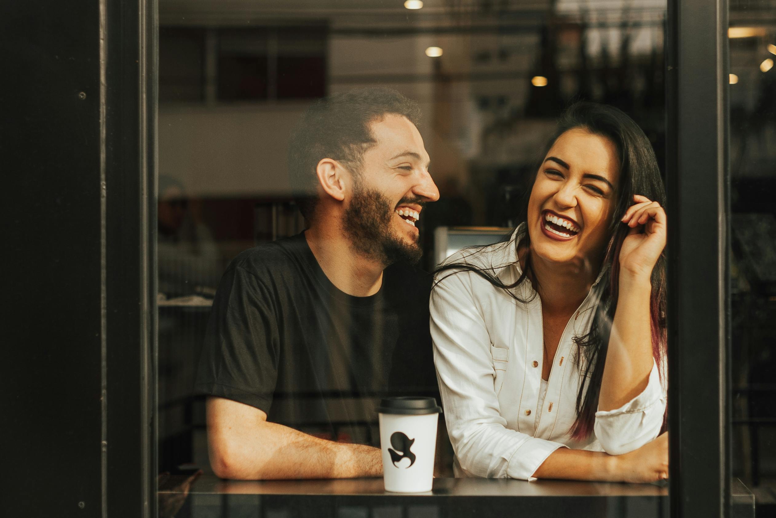Luiz Woellner Couple laughing in coffee shop