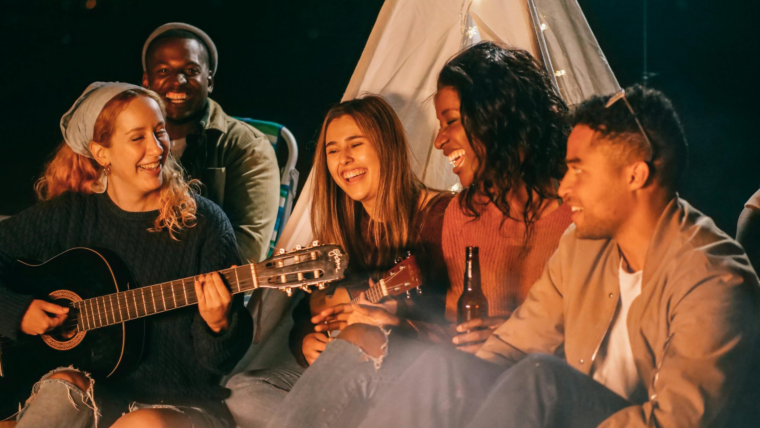 Kindel Media Friends sat around bonfire playing guitar