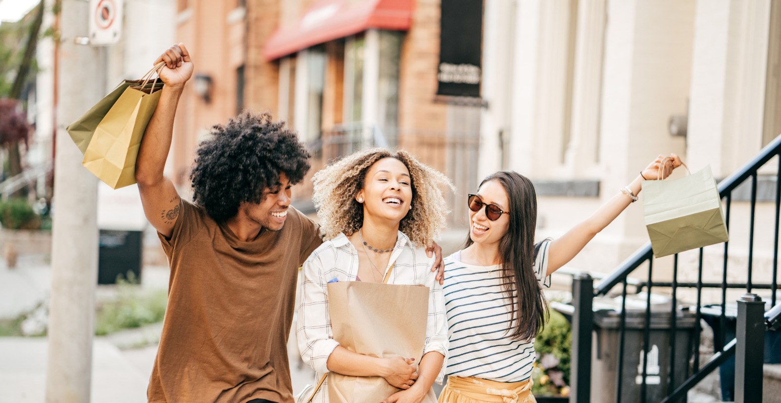 How to promote a Refer a Friend Page. Friends laughing in enjoyment with their shopping bags